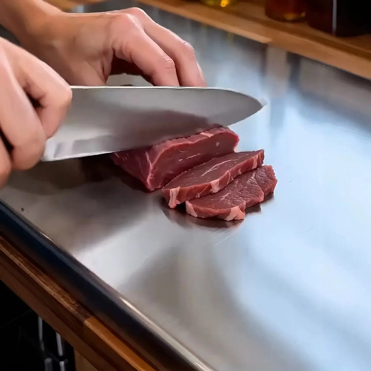 Grande planche à pétrir en acier inoxydable une personne qui coupe de la viande 
