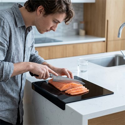 Planche a decouper  homme concentré découpe son poisson 