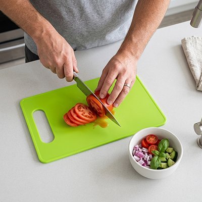 Planche a decouper homme coupe de tomate  